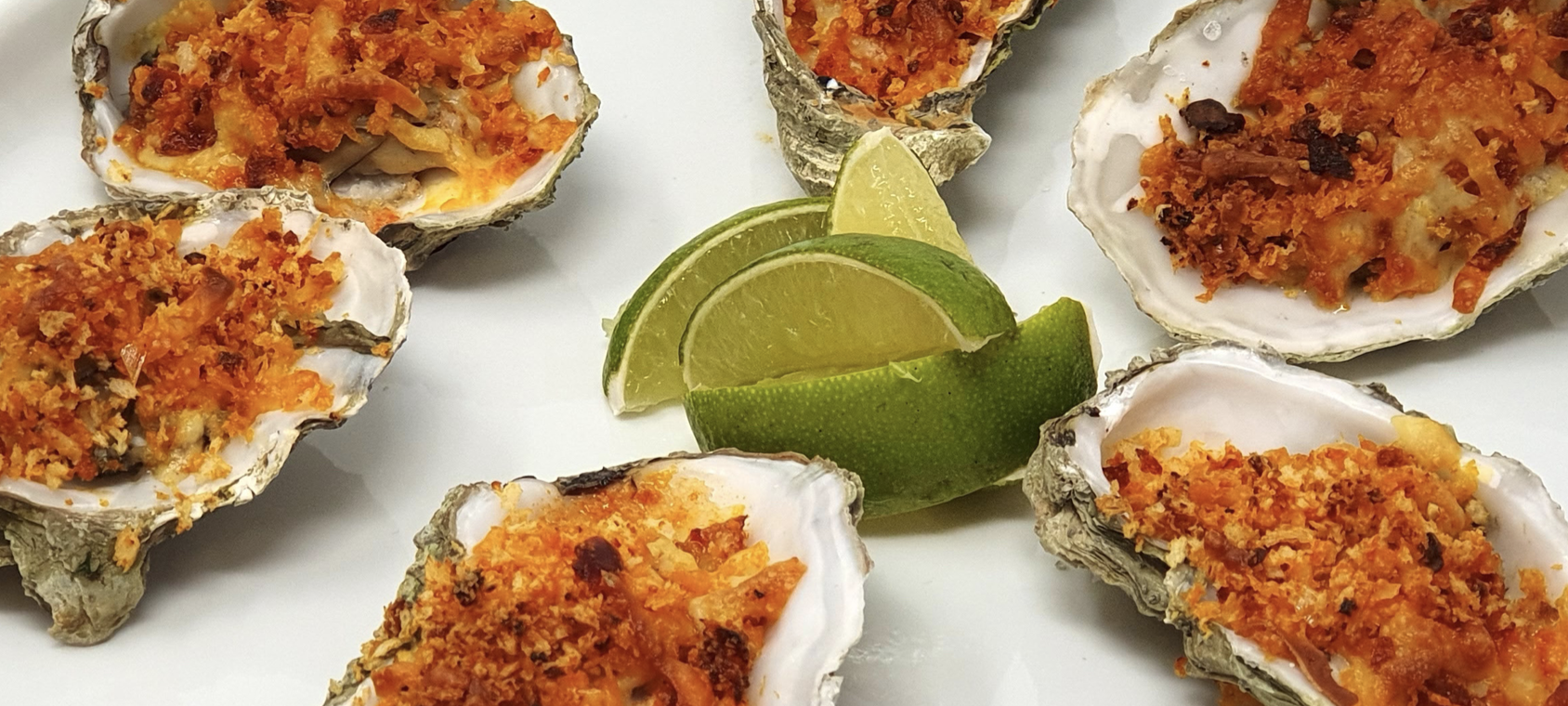 Baked oysters with a Rose Harissa and Manchego cheese crust dish