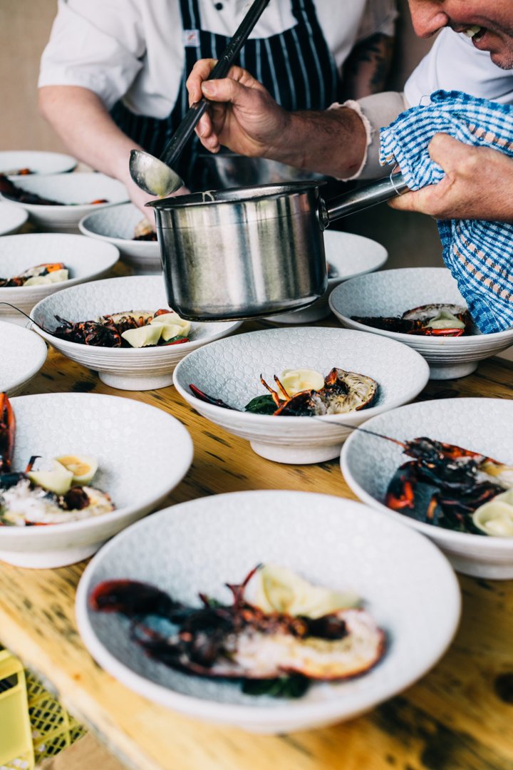 Chefs serving food into dishes